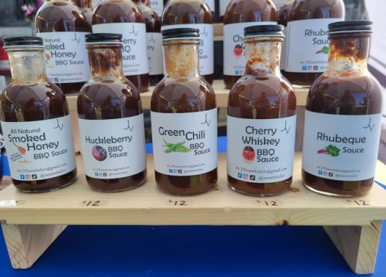 Bottles of JVEssentials BBQ sauces, including Huckleberry and Green Chili